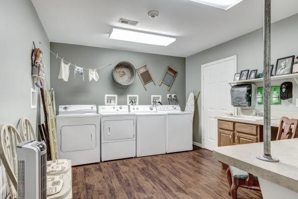 A clean and organized laundry room with washers, dryers, and decorative elements.