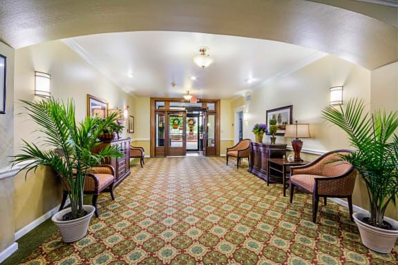 A well-decorated lobby area with seating arrangements and potted plants.