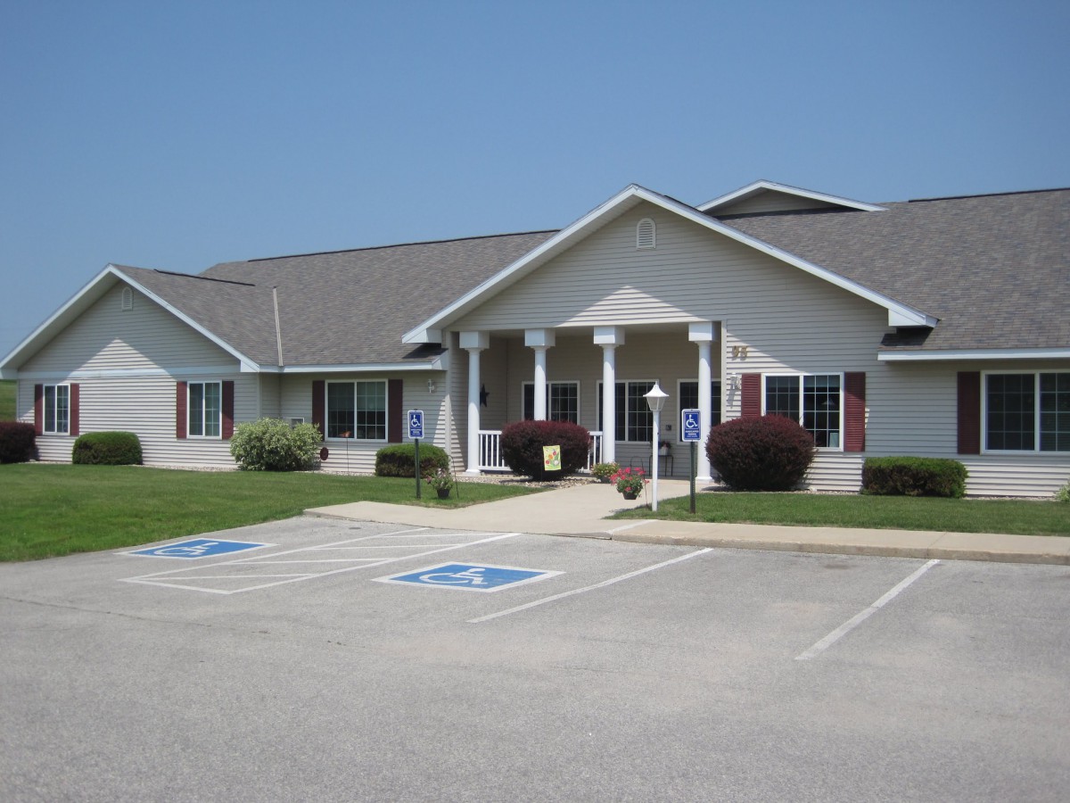 A single-story building with a front entrance surrounded by accessible parking spaces.