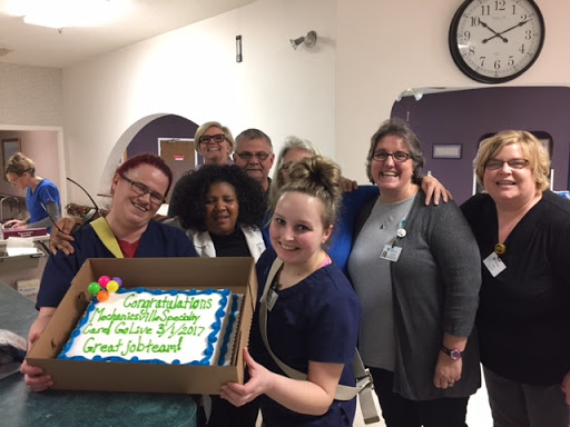 A joyful team celebration with a congratulatory cake.