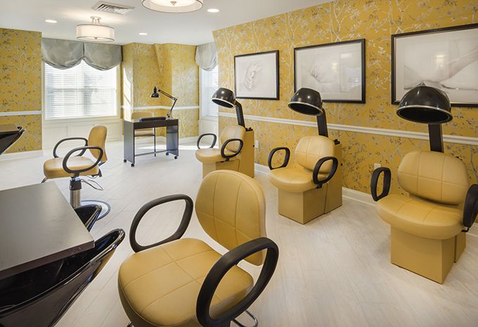 A modern beauty salon with stylish chairs and hair dryers.