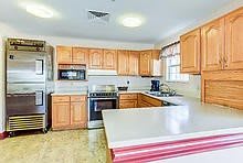 A spacious kitchen with wooden cabinets and modern appliances.