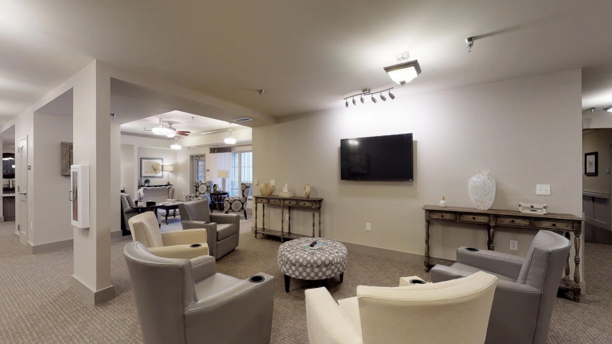 A modern living room with comfortable seating and a wall-mounted television.