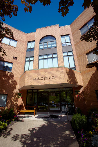 A modern brick building featuring large windows and an inviting entrance.