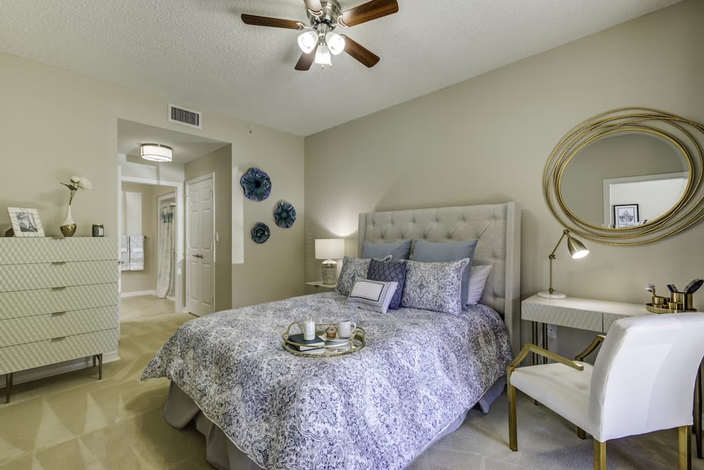 A cozy and stylishly decorated bedroom with a plush bed, accent pillows, and modern lighting.