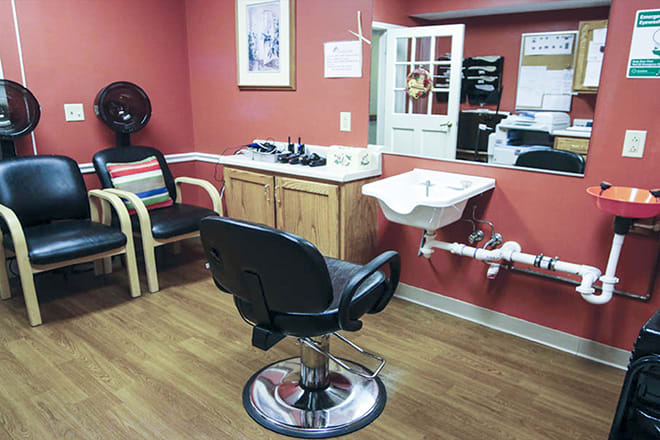A cozy salon featuring a barber chair, sink, and additional seating.