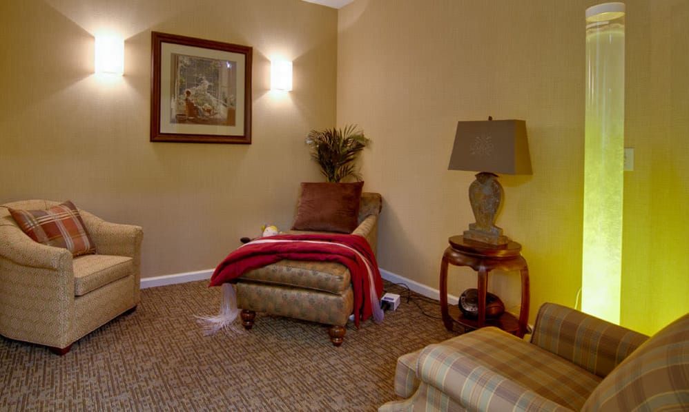 A cozy living room corner with an armchair and a lamp.