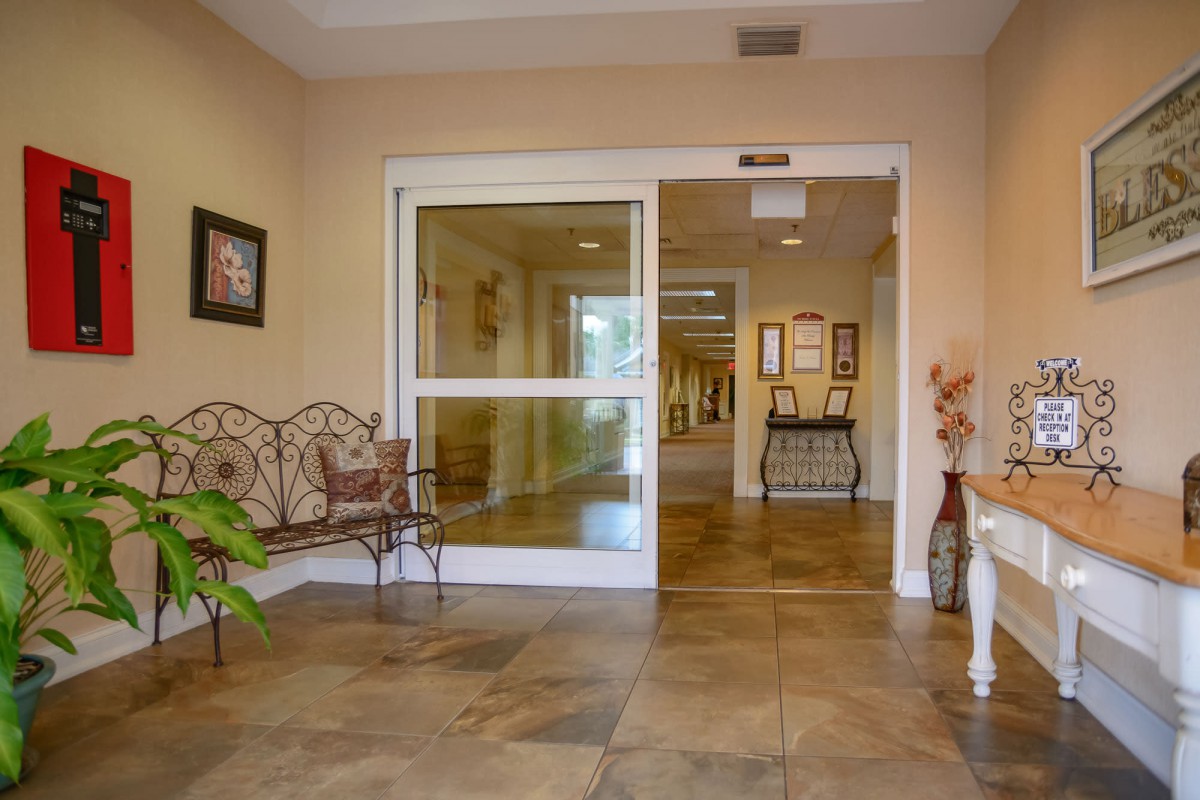 A well-decorated lobby area with seating and glass doors leading to a hallway.