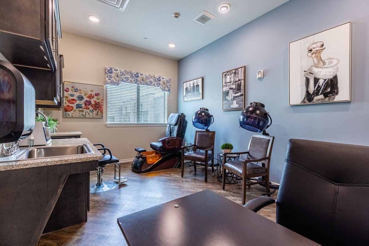 A modern office waiting room with chairs, desk, and artwork.
