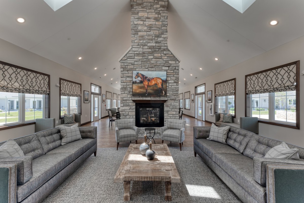 A modern living room featuring a stone fireplace, two sofas, and a wooden coffee table.