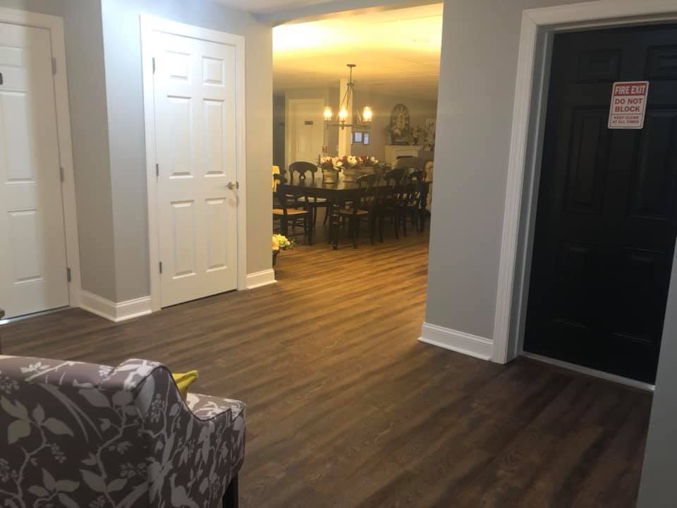 A cozy living space featuring a wooden floor and a dining area with elegant lighting.