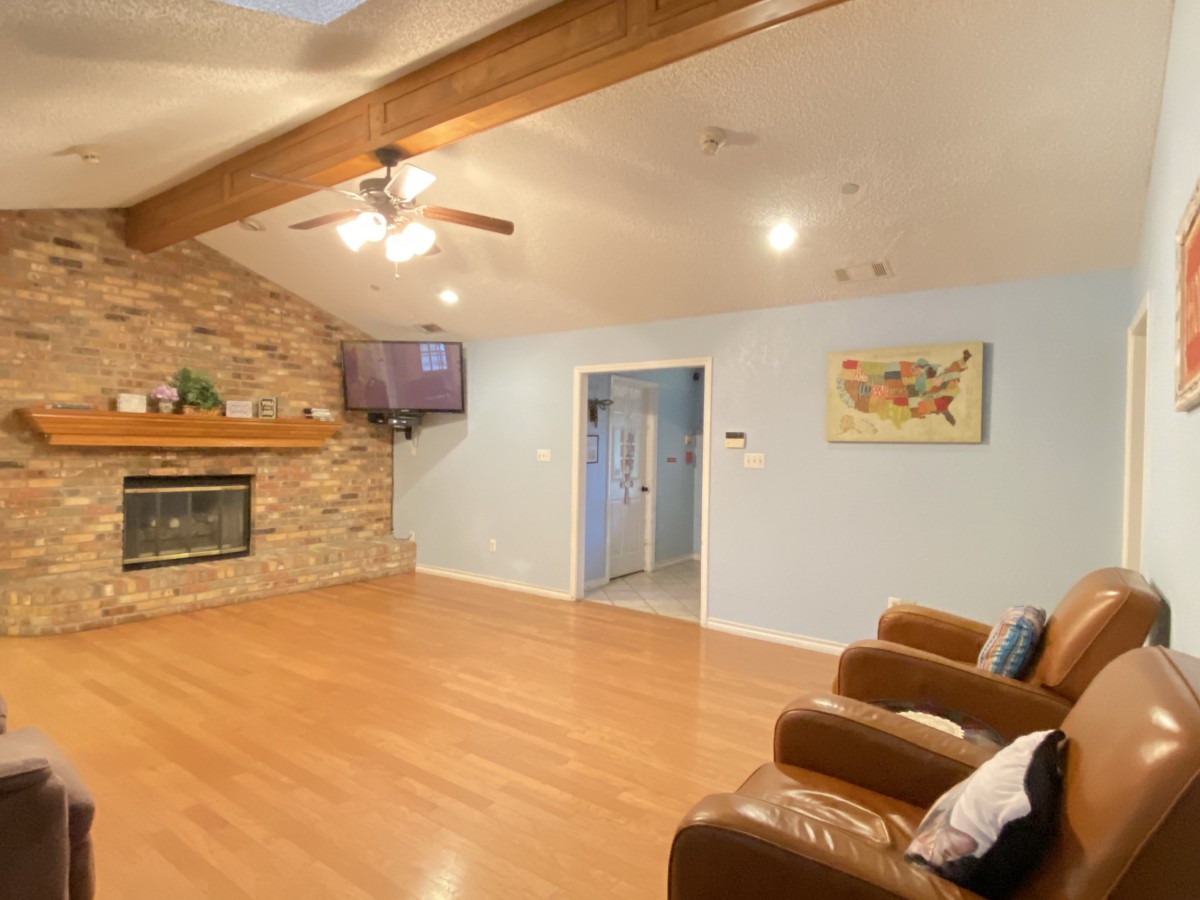 Spacious living room with a fireplace and vaulted ceiling.