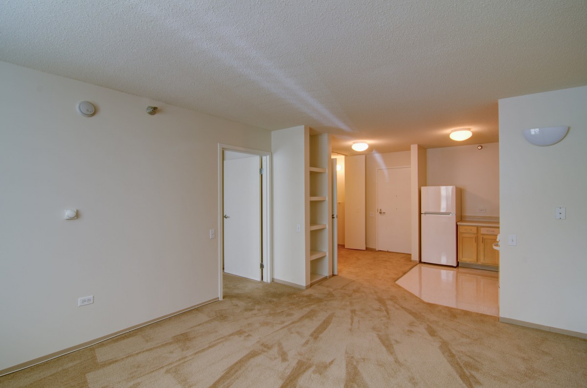 A modern and empty apartment interior with an open living area and kitchen.