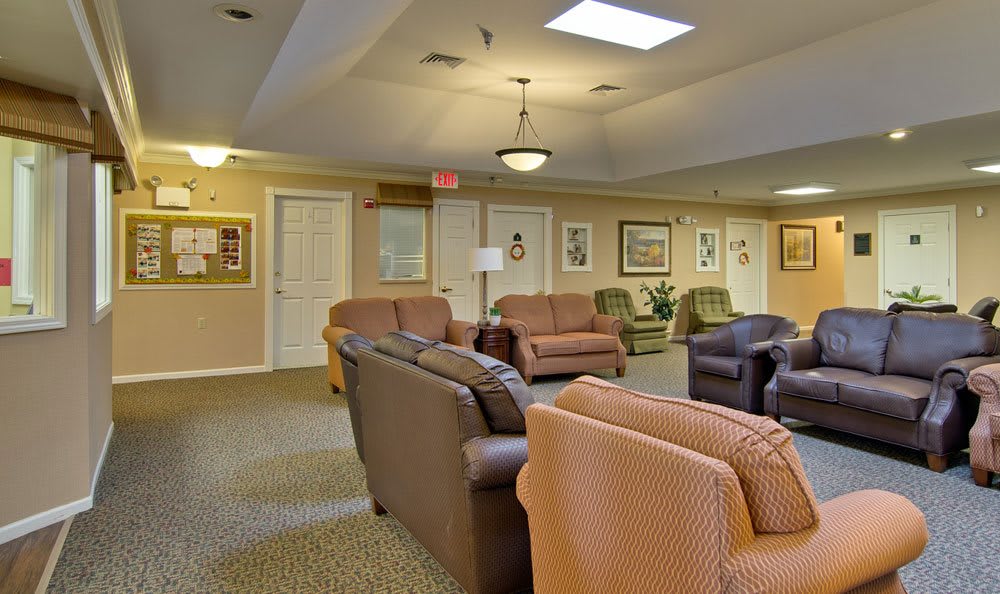 A cozy living room with several sofas and warm lighting.