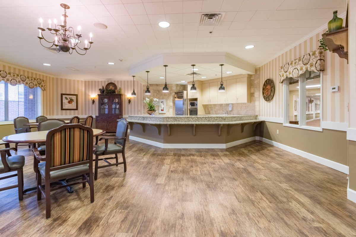 A spacious kitchen and dining area featuring modern decor with wood flooring and pendant lighting.