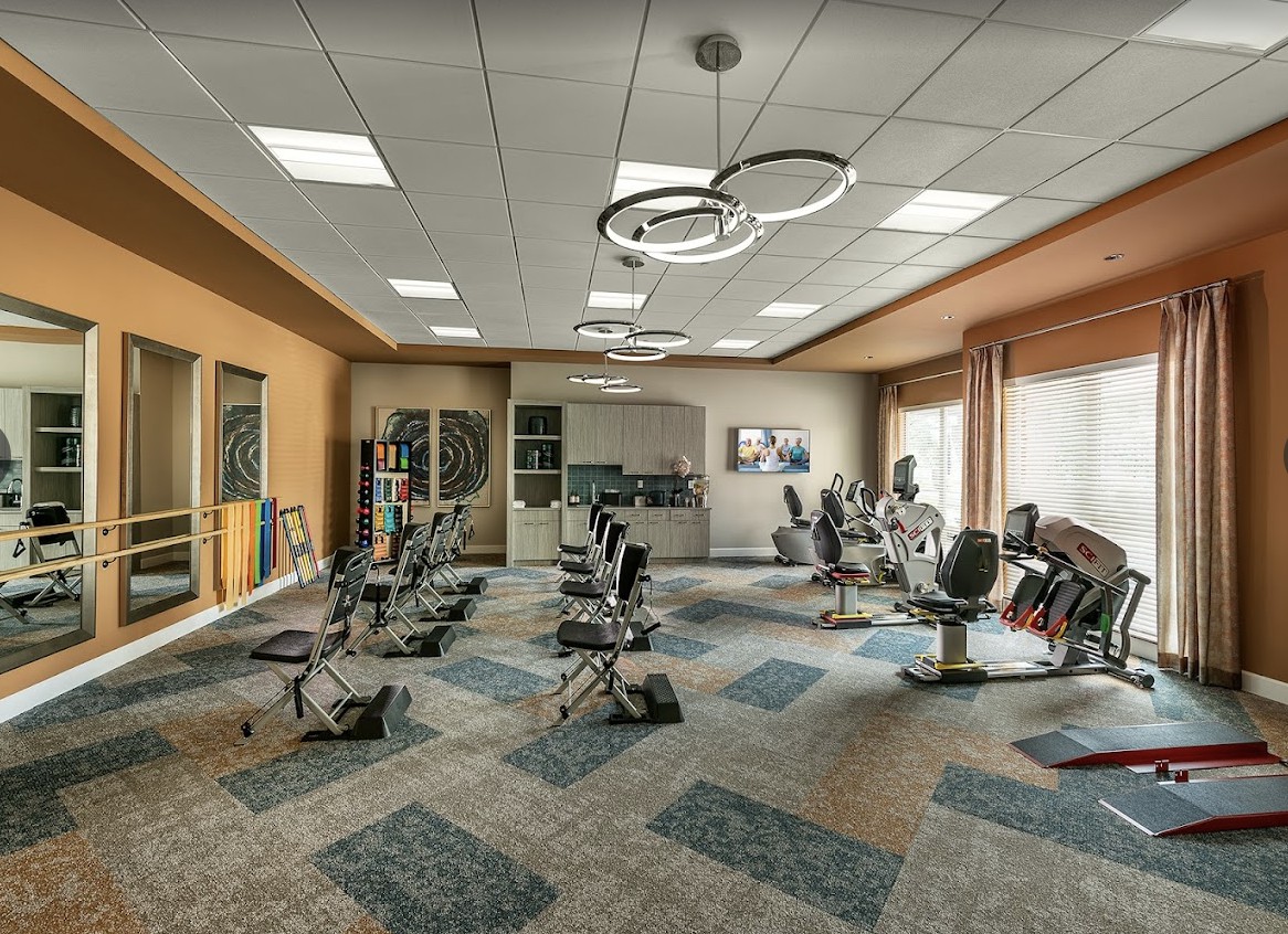 A modern gym with various exercise equipment and a spacious layout.