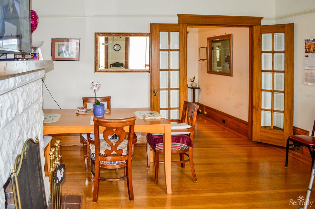 A cozy dining room with wooden flooring and elegant furniture.