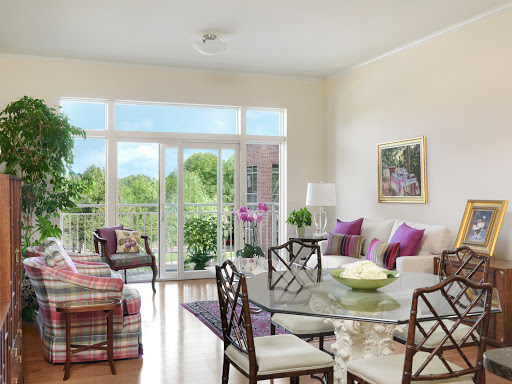 A bright and inviting living room with modern furniture, a dining table, and vibrant plants, creating a cozy atmosphere.