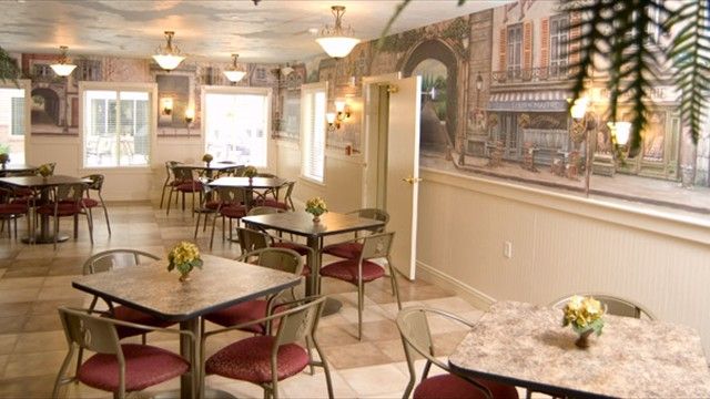 A charming cafe interior with elegant tables and artistic wall decorations.