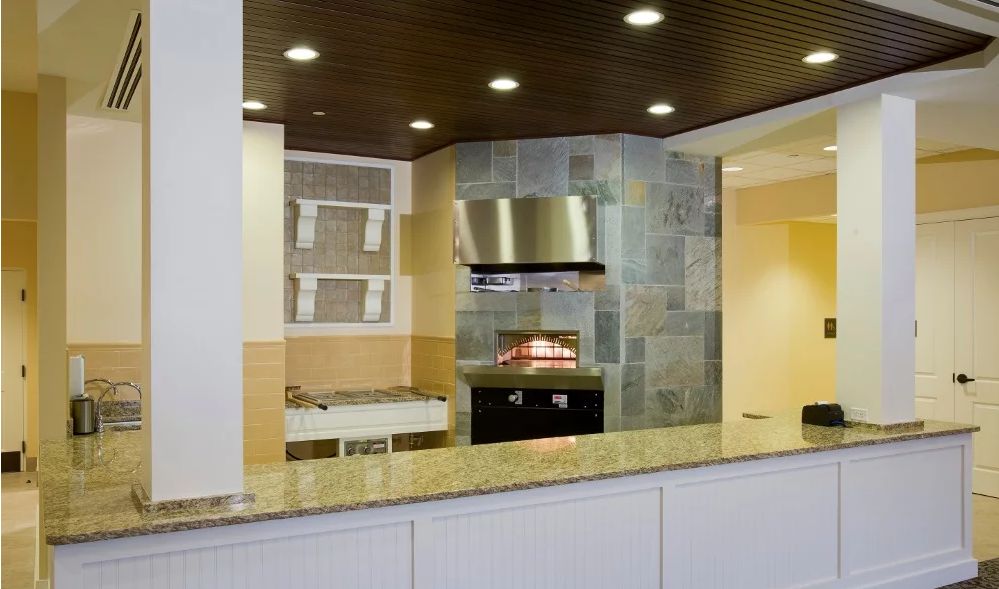Modern kitchen with a stone backsplash, built-in oven, and sleek countertop.