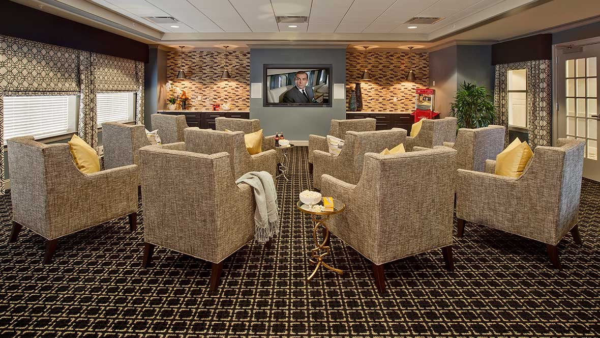 A comfortable lounge area with upholstered chairs facing a television.
