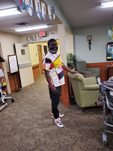 A person stands in a cozy lounge area, wearing a vibrant casual outfit.