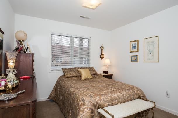 A cozy bedroom with a bed, nightstand, and decorative elements.