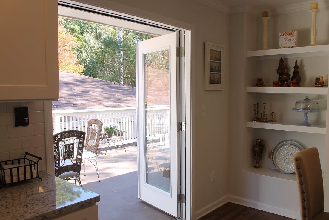 A cozy interior with French doors leading to a sunlit patio.