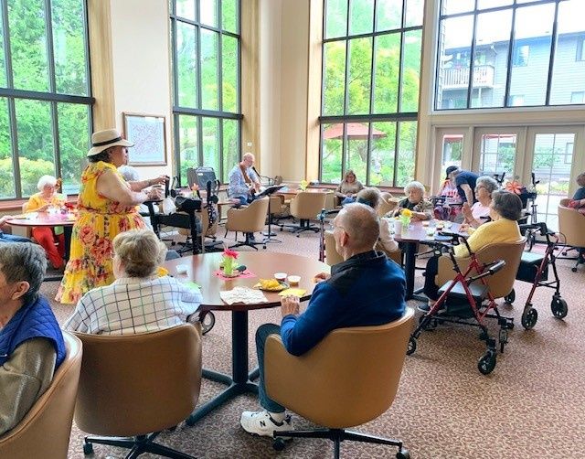 A group of seniors enjoying a social gathering in a bright, spacious room.