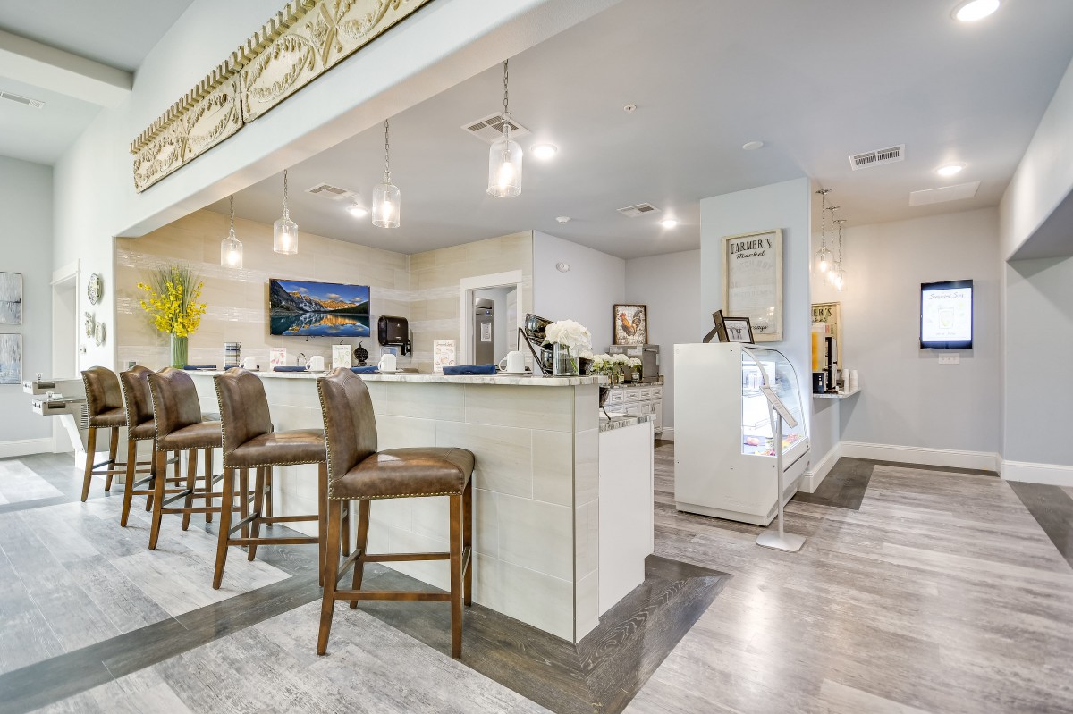 A modern kitchen interior with bar stools and elegant lighting.