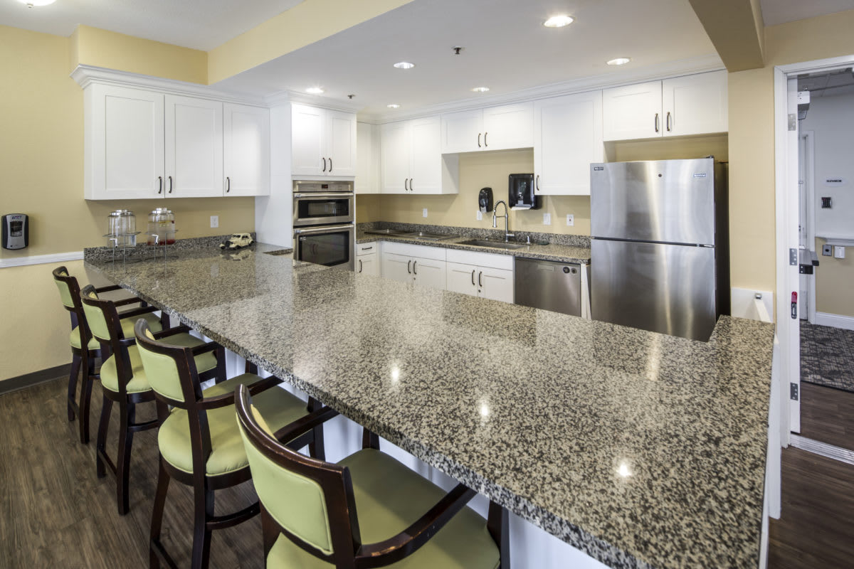 A modern kitchen with granite countertops and stainless steel appliances.