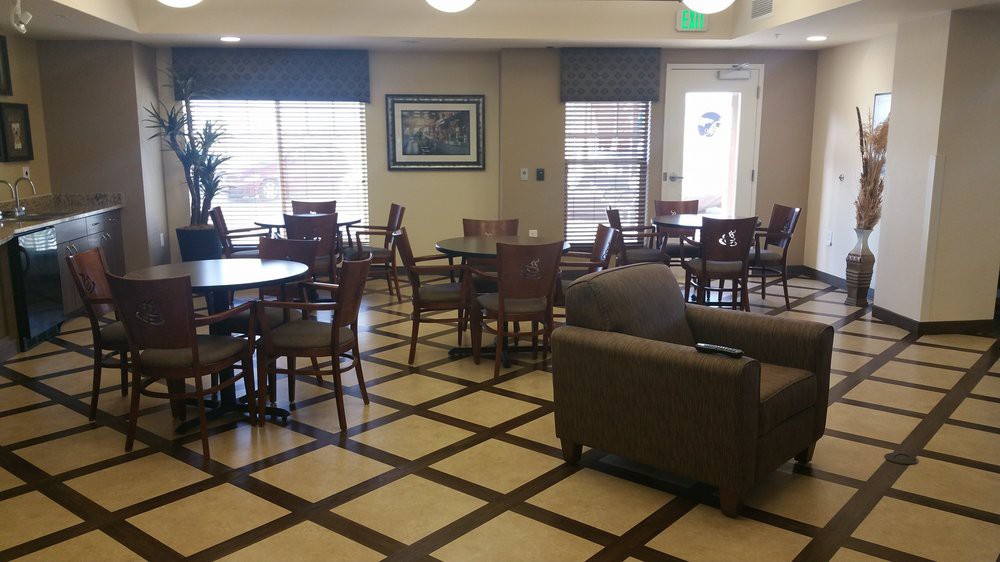 A cozy cafe lounge with tables and chairs arranged on a patterned floor.
