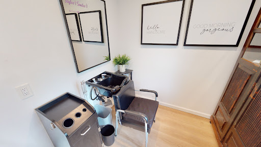 A modern hair salon station featuring minimalist decor and a stylish setup.