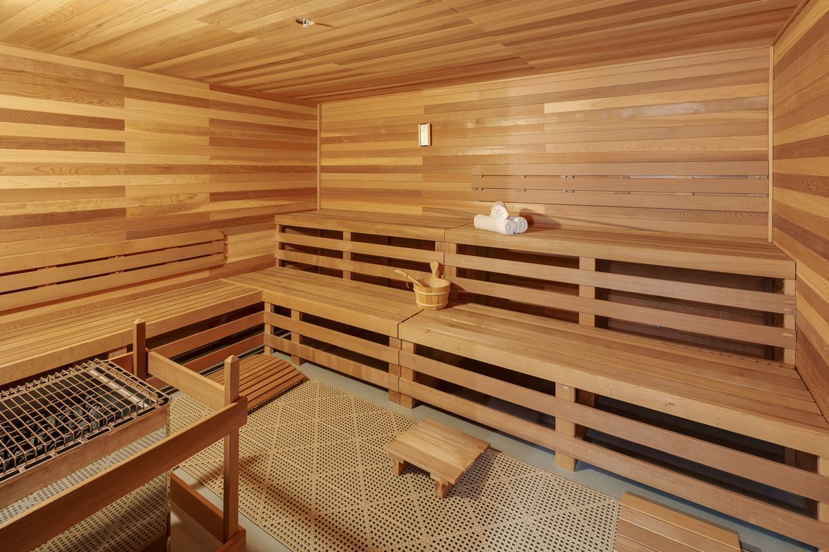 A wooden sauna with benches and a cozy atmosphere, perfect for relaxation.
