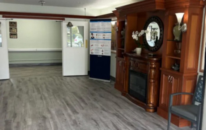A cozy interior with a wooden fireplace and mirror, complemented by stylish flooring.
