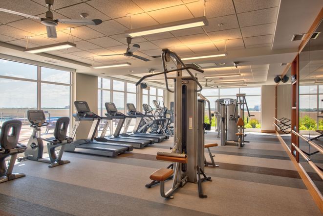 A modern gym with various exercise equipment, including treadmills and weight machines.