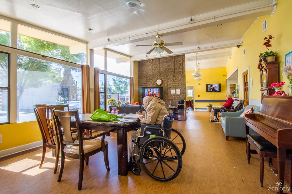 A common area in a nursing home with elderly residents relaxing and socializing.