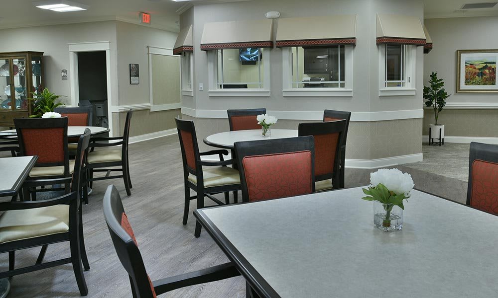 A clean and minimalist dining area with neatly arranged tables and chairs.