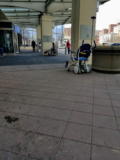 A quiet moment at a shopping center entrance, featuring a stroller and people walking by.