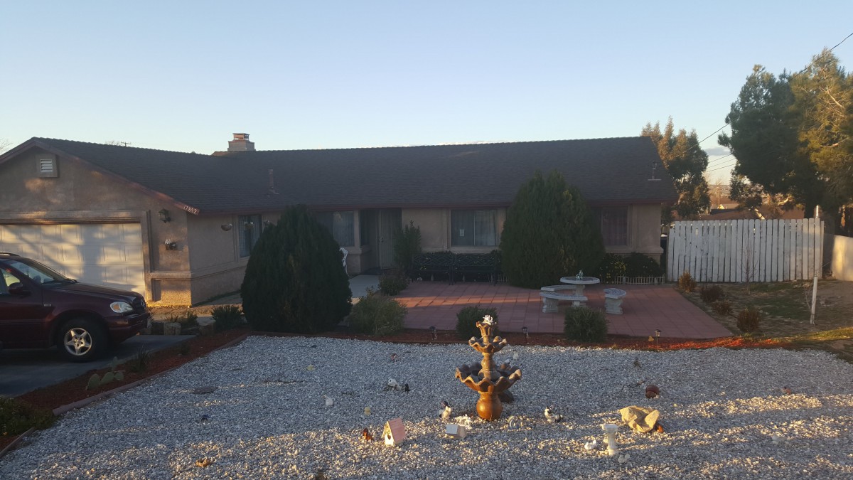 A residential house with a landscaped front yard at sunset.