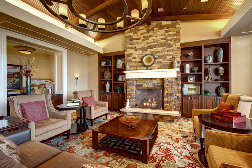 A beautifully designed living room featuring a stone fireplace, comfortable seating, and elegant decor.