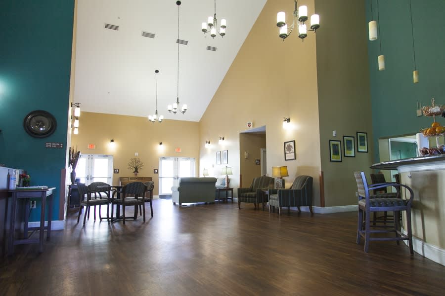 A spacious, well-lit interior room with chandeliers and comfortable seating.
