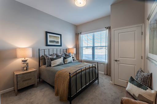 A beautifully designed modern bedroom featuring a queen-sized bed, soft lighting, and ample natural light.