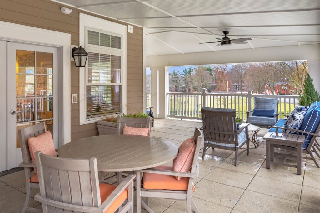 A cozy covered patio with comfortable seating and a dining table, perfect for relaxation and outdoor gatherings.