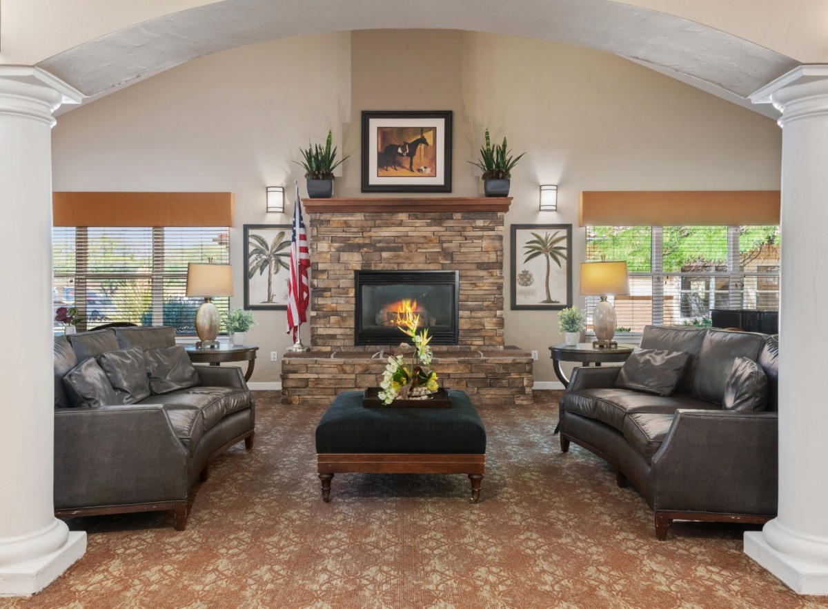 A traditional living room with a stone fireplace, leather sofas, and elegant decor.
