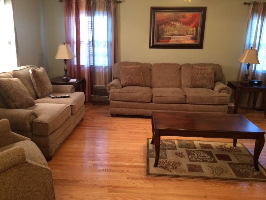 A cozy living room with matching sofas, a wooden coffee table, and warm lighting.