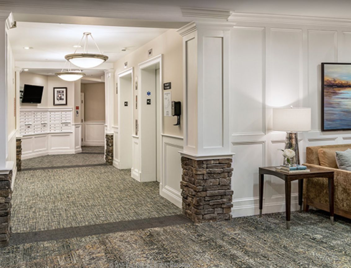 A well-lit hotel lobby featuring elevators and comfortable seating.