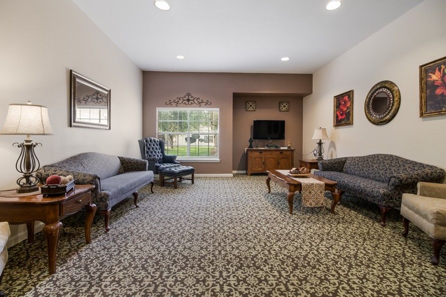 A comfortable living room featuring classic furniture and a patterned carpet.