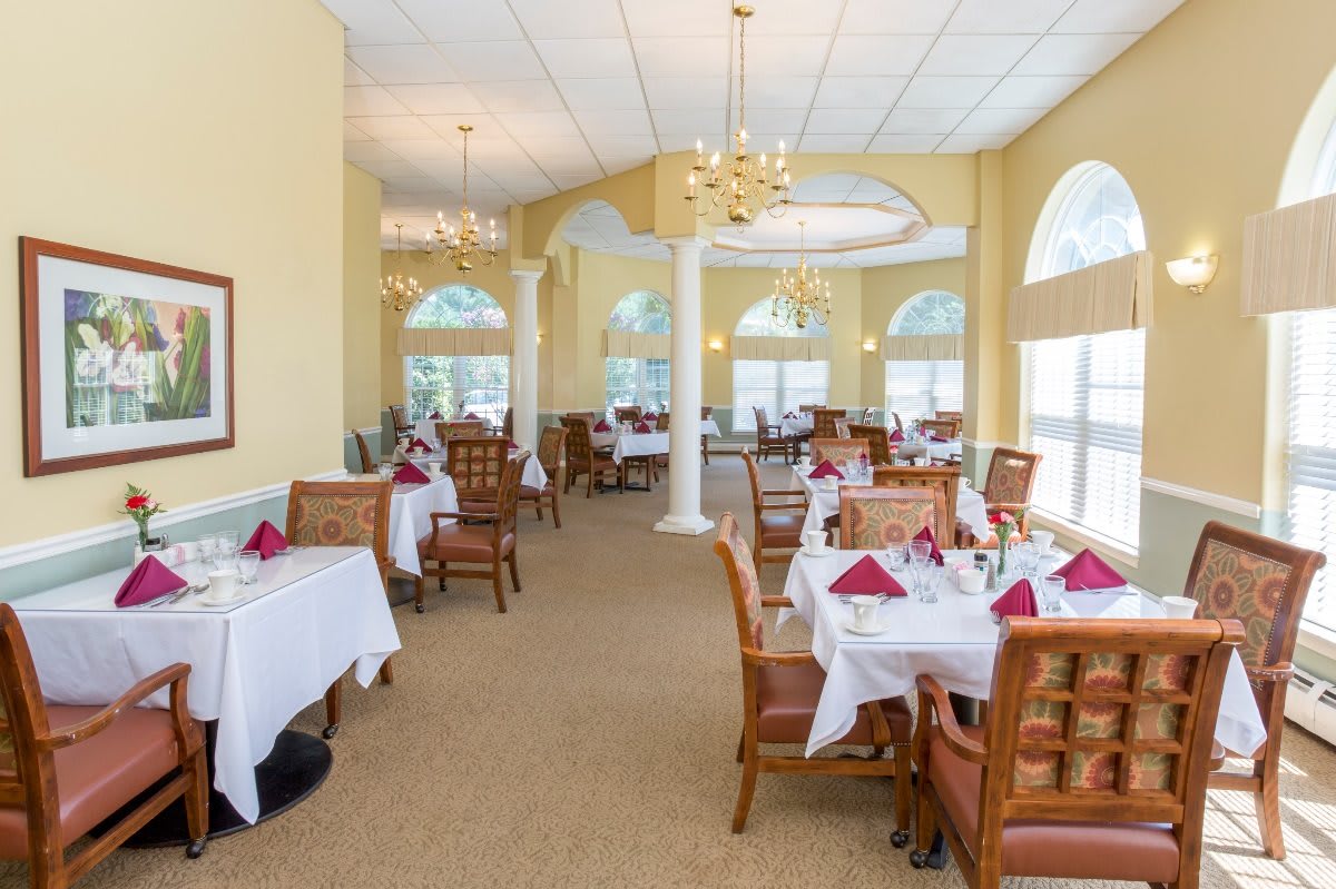 Elegant restaurant dining area with neatly set tables and large windows.