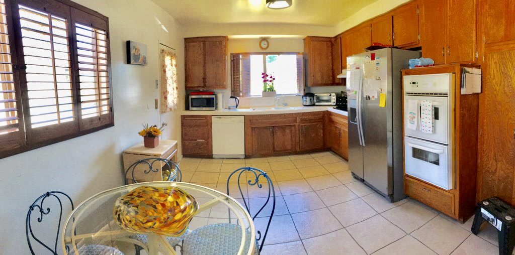 A bright kitchen with wooden cabinets, modern appliances, and a cozy dining area.
